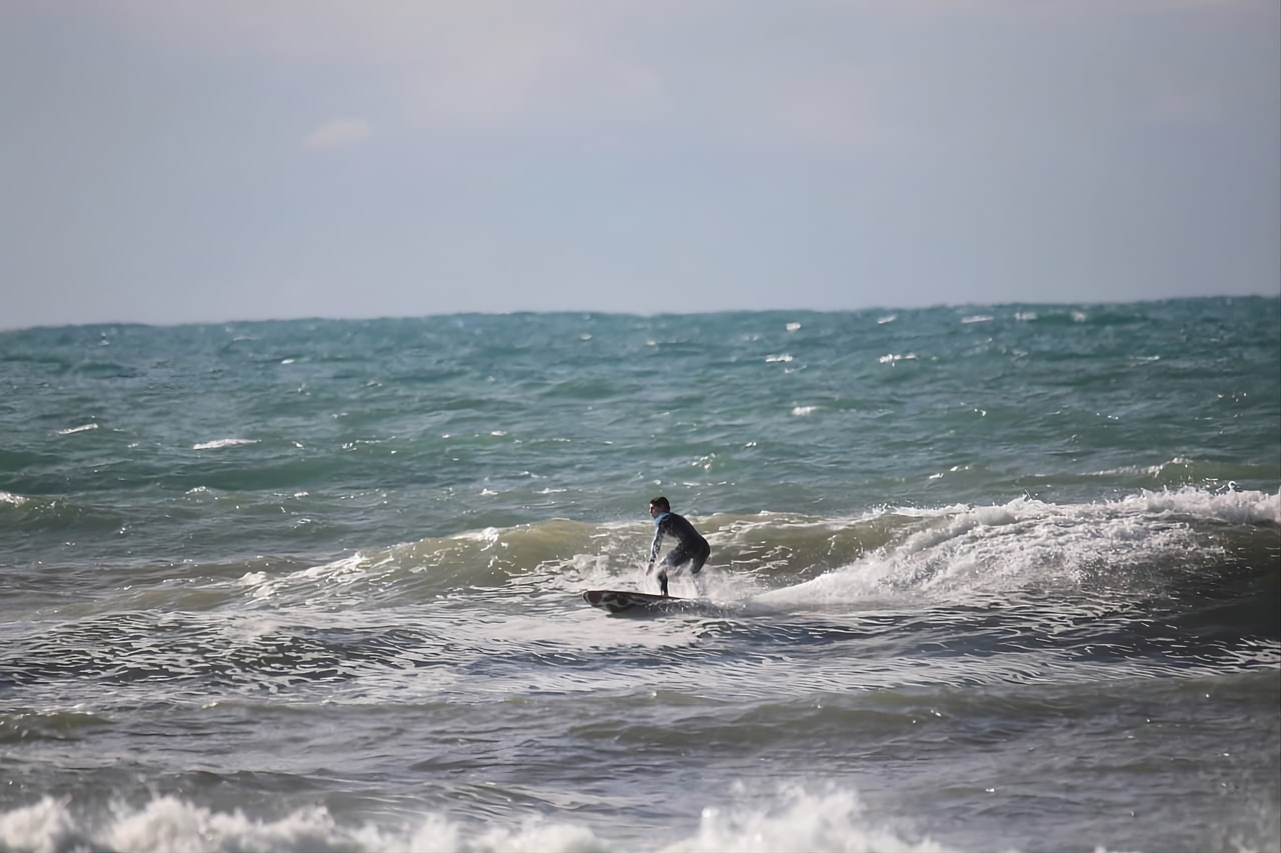 Spiaggia di Paestum con surfisti e montagne sullo sfondo